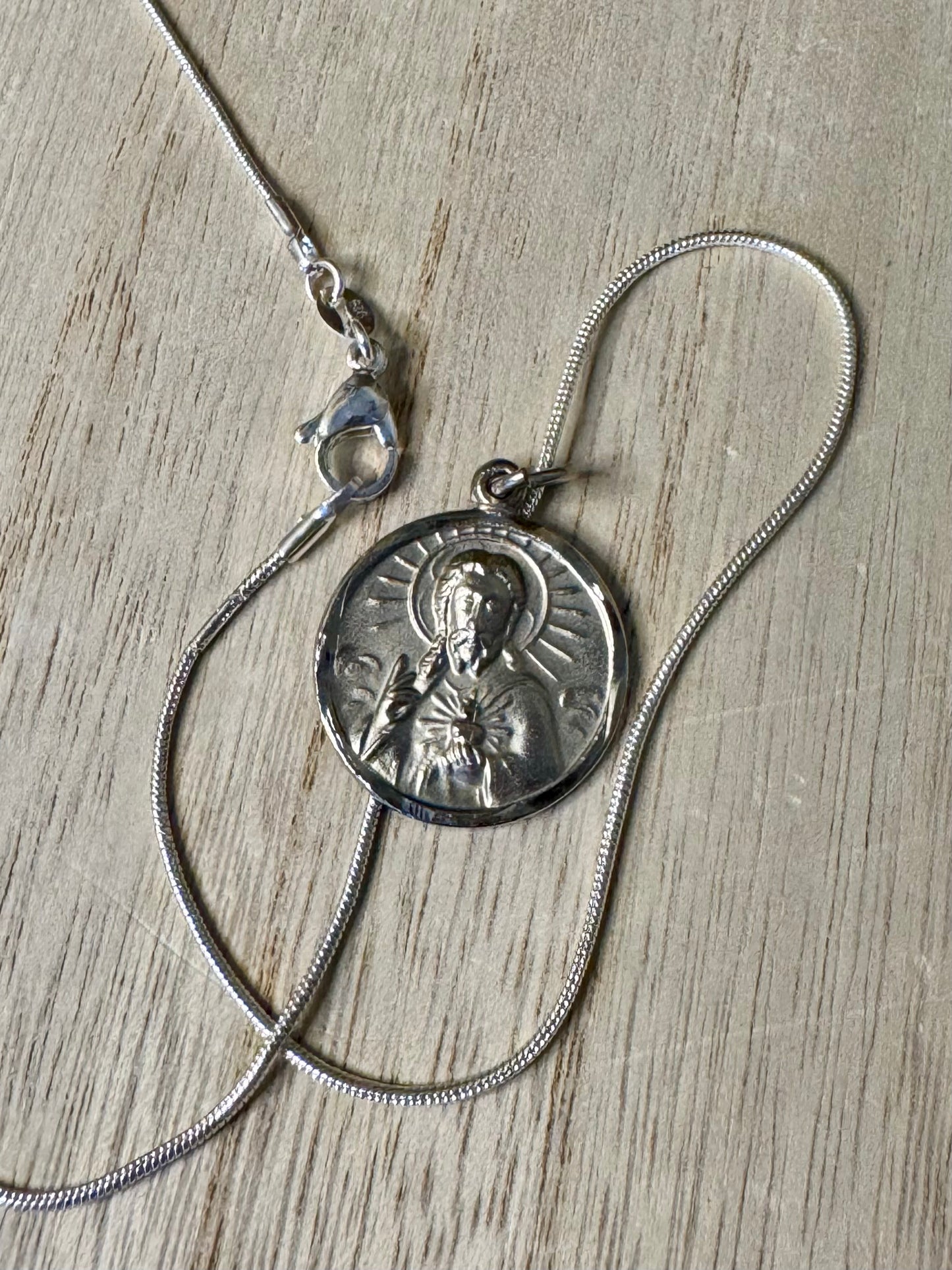 Silver necklace with a pendant on a wooden surface