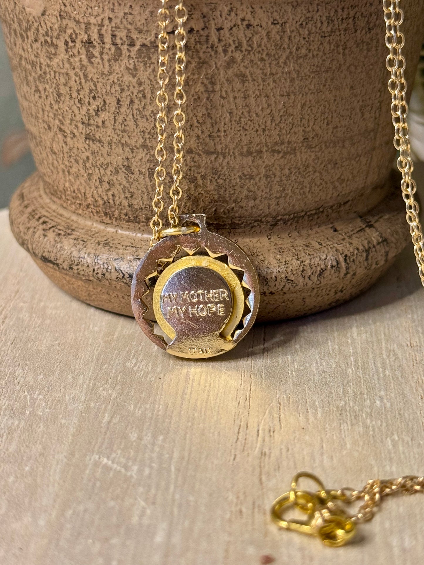 Gold necklace with a pendant on a wooden surface