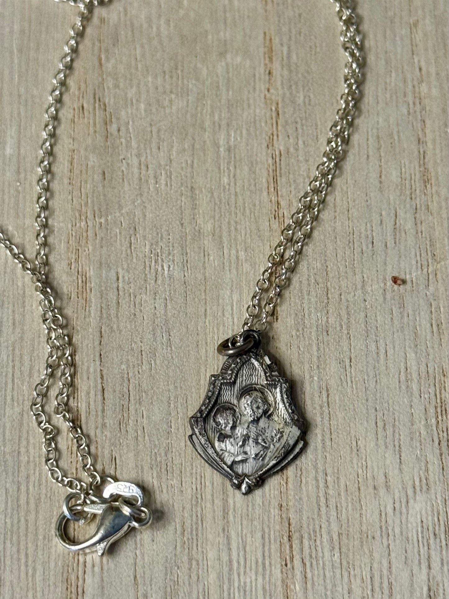 Silver necklace with a pendant on a wooden surface