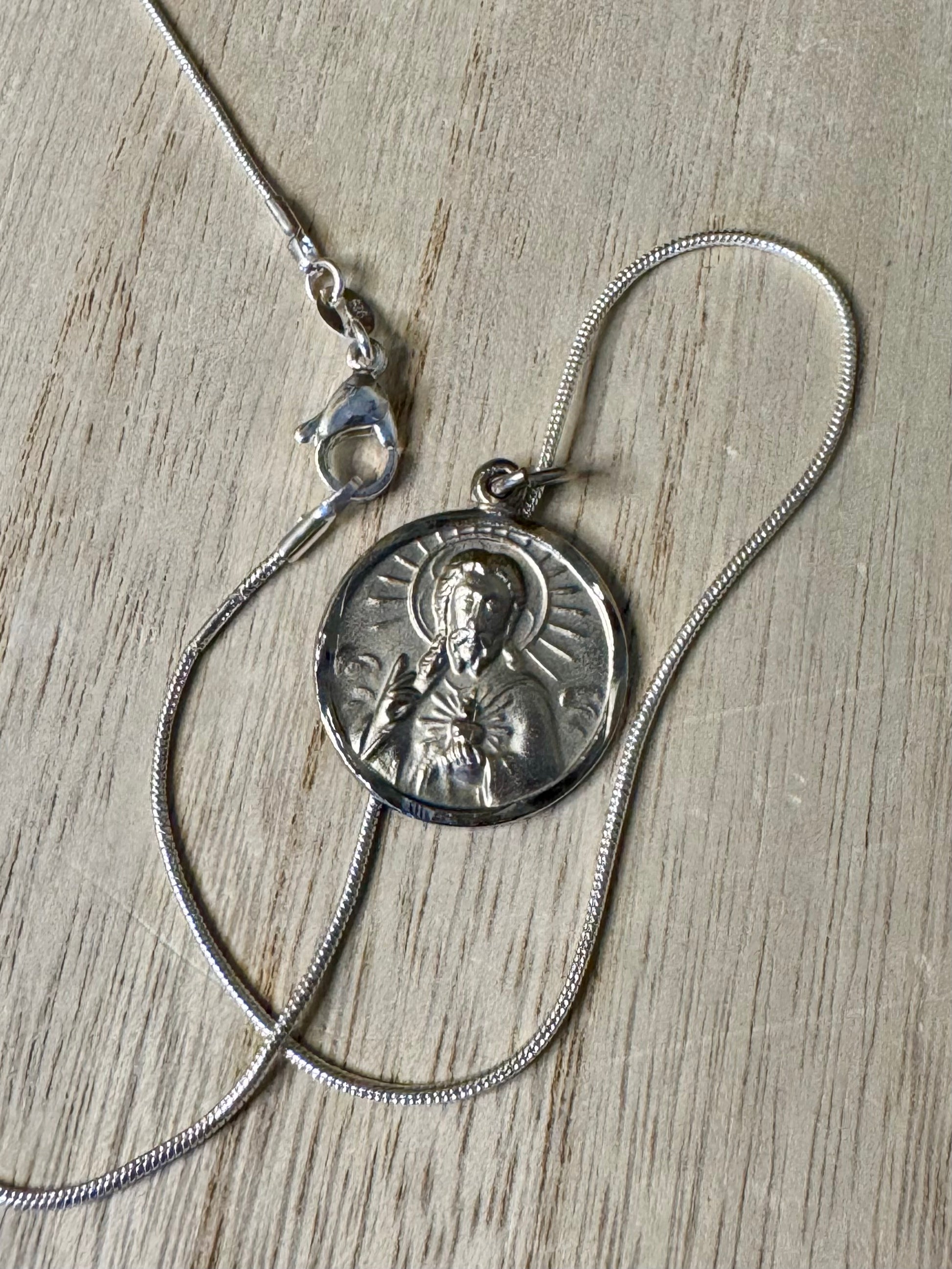 Silver necklace with a pendant on a wooden surface