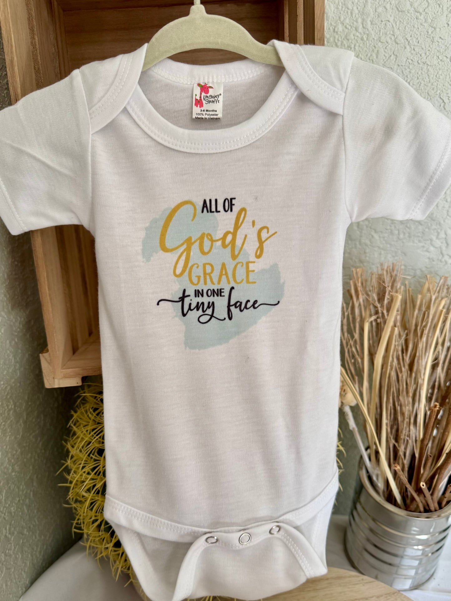 All God’s Grace in One Tiny Face Baby Onesie