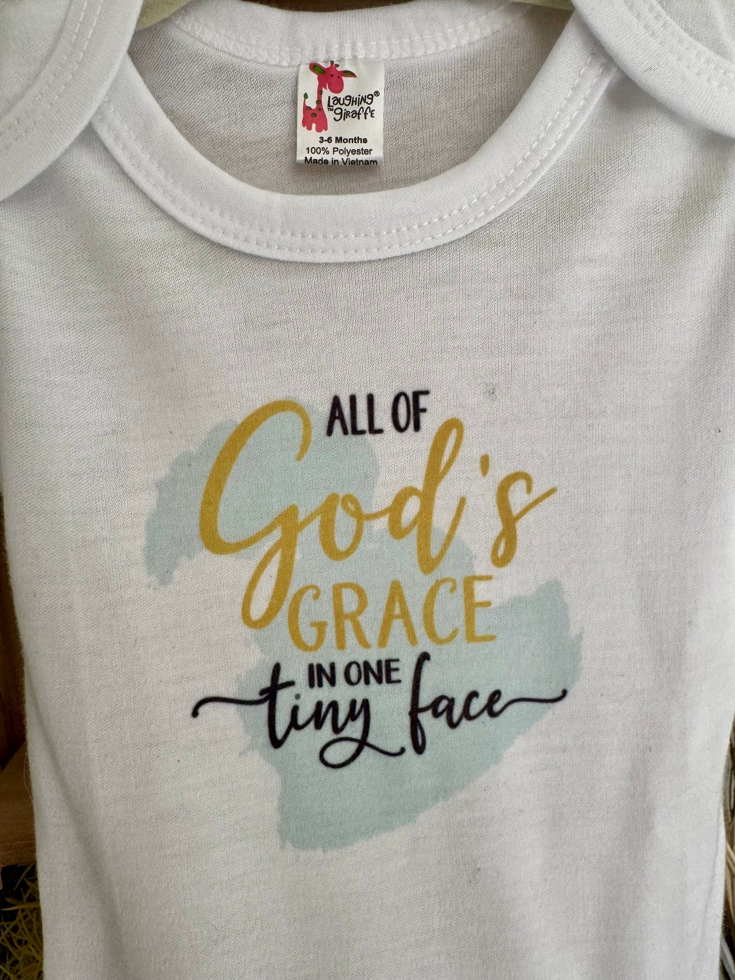 All God’s Grace in One Tiny Face Baby Onesie