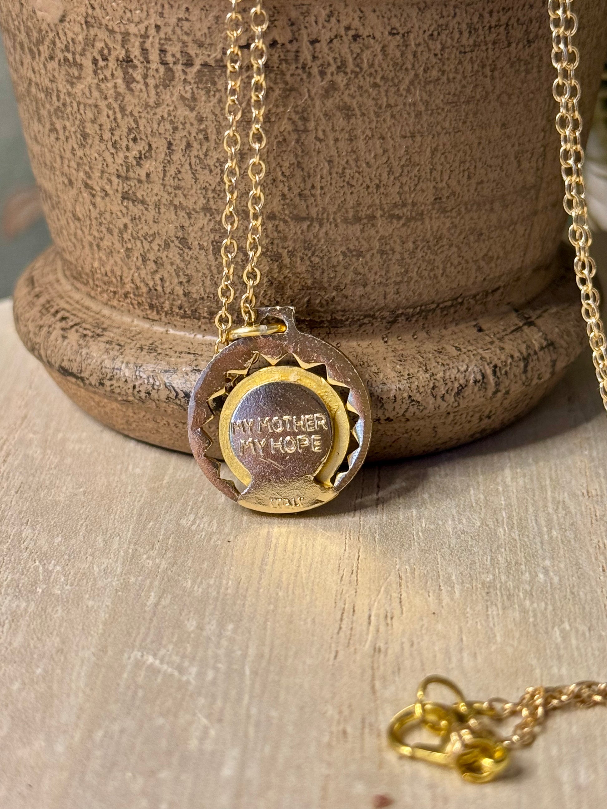 Gold necklace with a pendant on a wooden surface