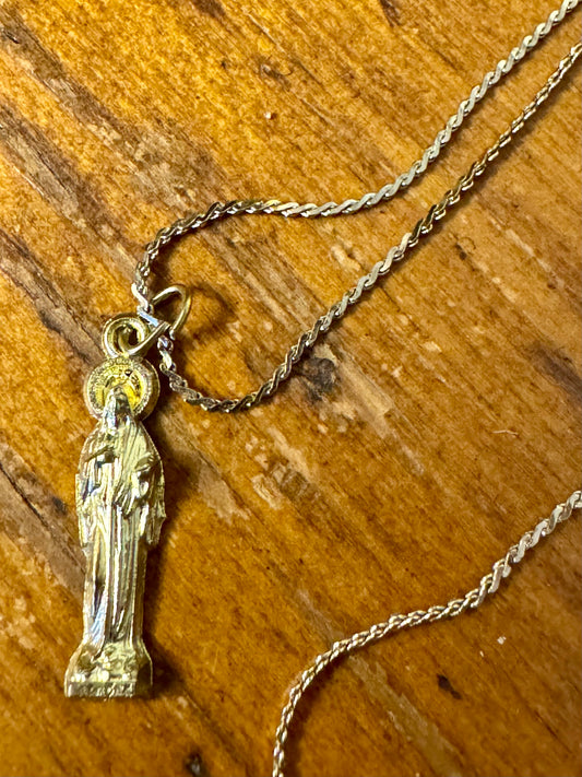 Gold necklace with a pendant on a wooden surface