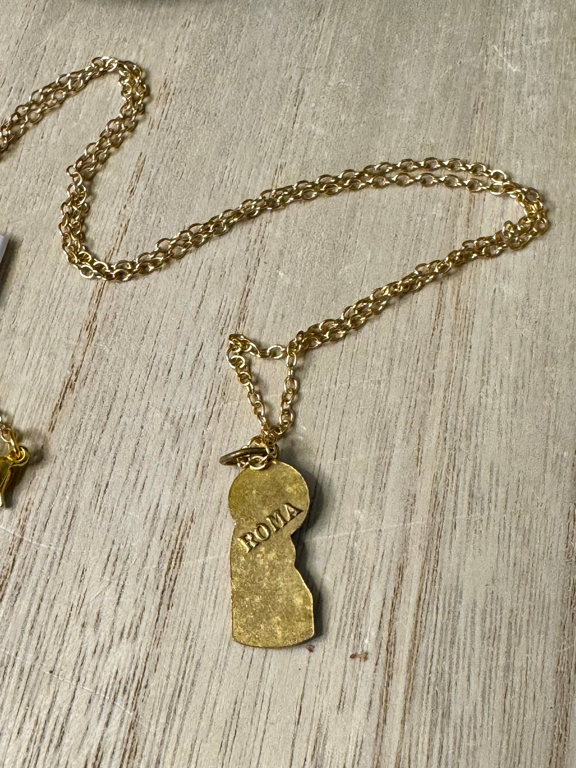 Gold necklace with a pendant on a wooden surface