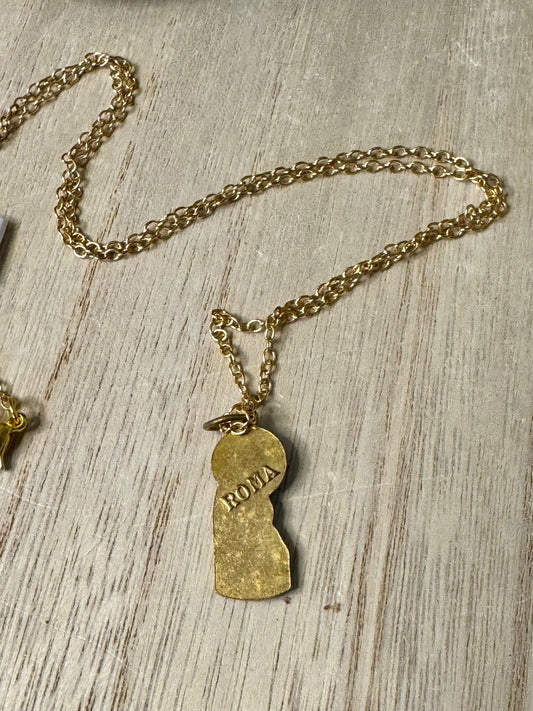 Gold necklace with a pendant on a wooden surface