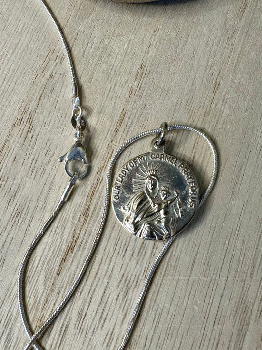 Silver necklace with a pendant on a wooden surface