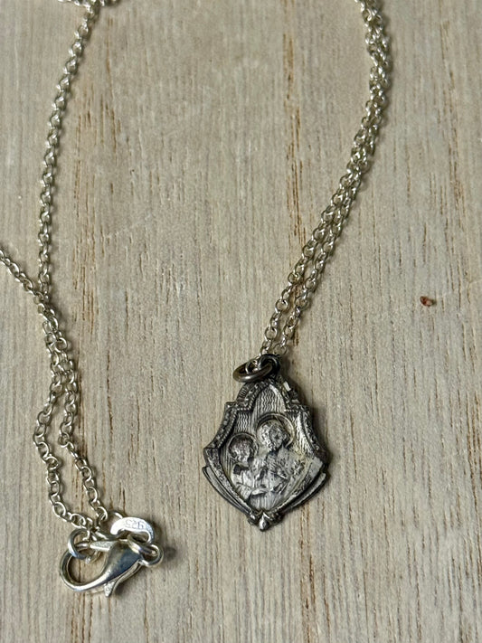 Silver necklace with a pendant on a wooden surface