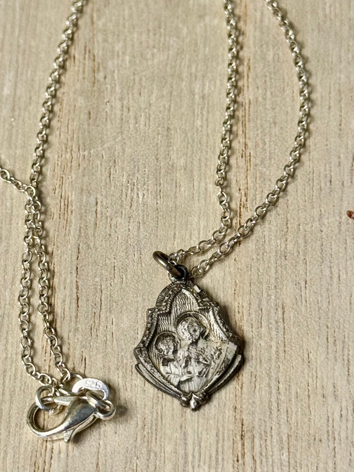 Silver necklace with a pendant on a wooden surface