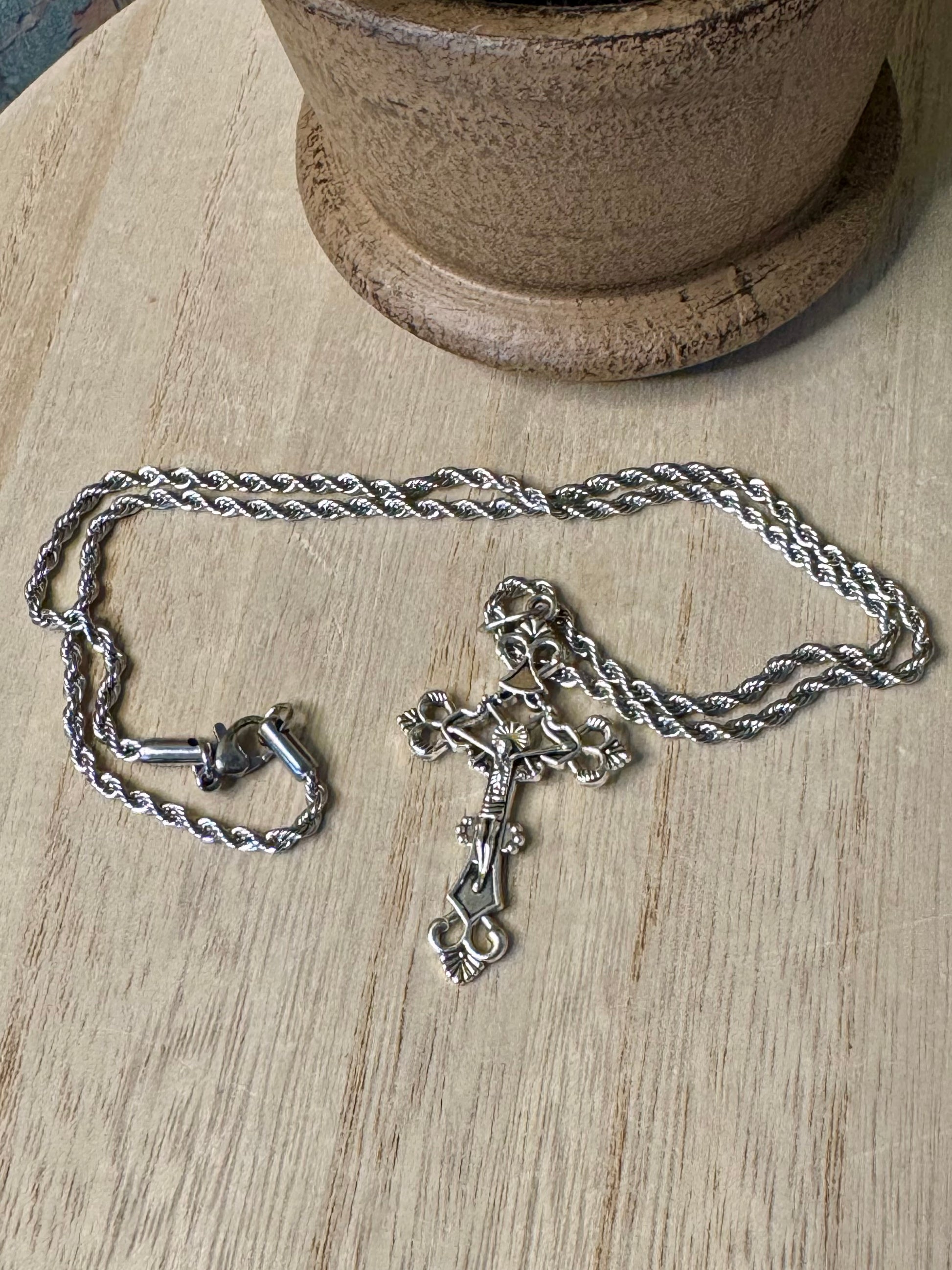 Silver chain necklace with a pendant on a wooden surface