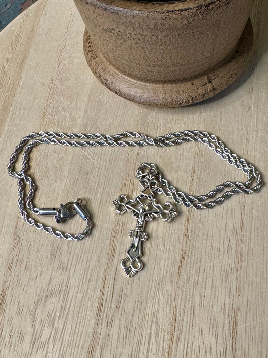 Silver chain necklace with a pendant on a wooden surface