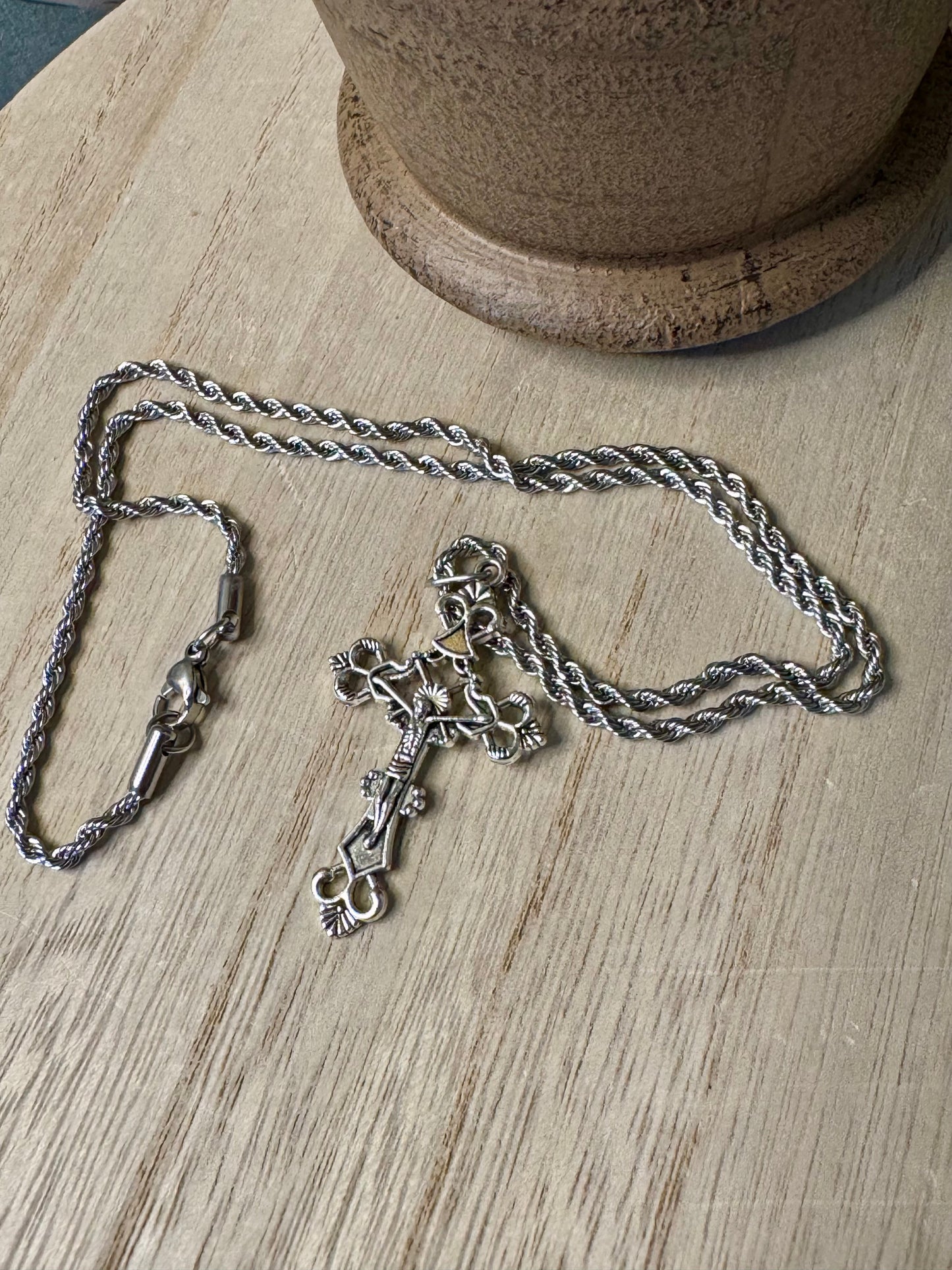 Silver necklace with a key pendant on a wooden surface