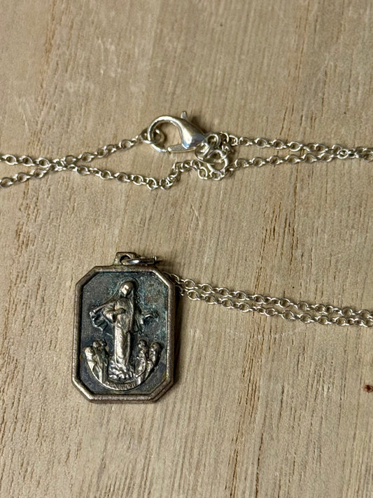 Silver necklace with a pendant on a wooden surface
