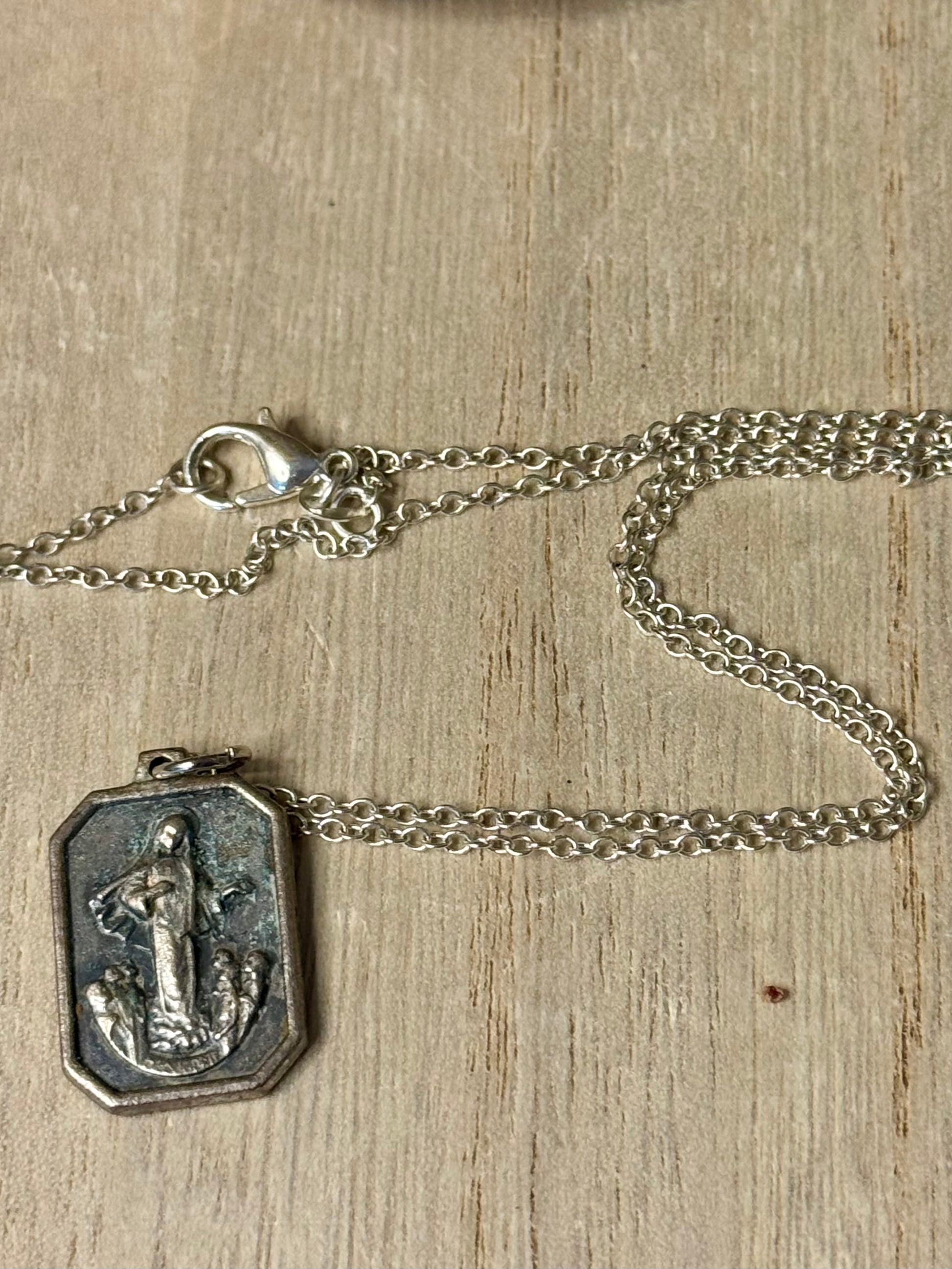 Silver necklace with a pendant on a wooden surface