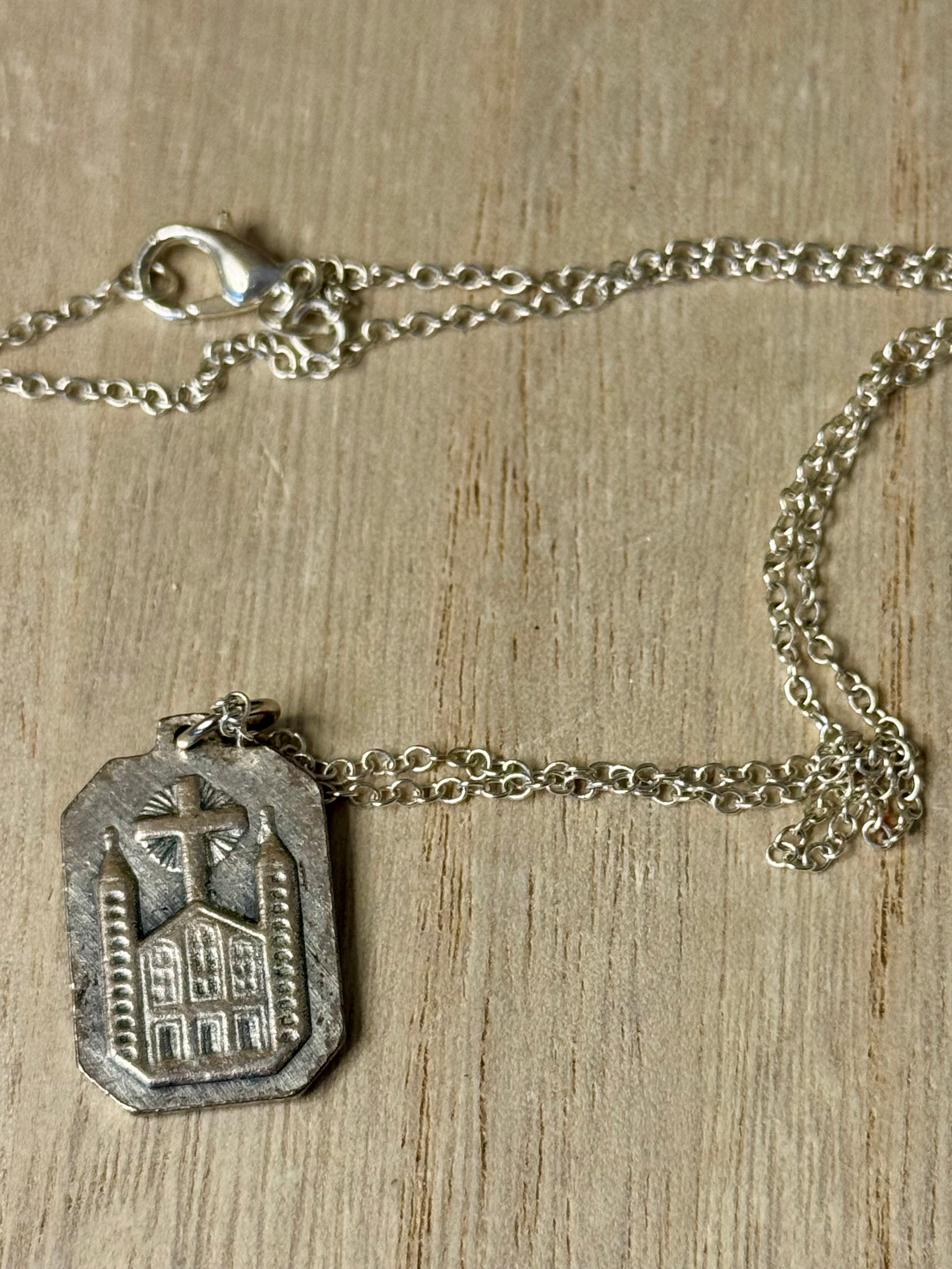 Silver necklace with a pendant on a wooden surface