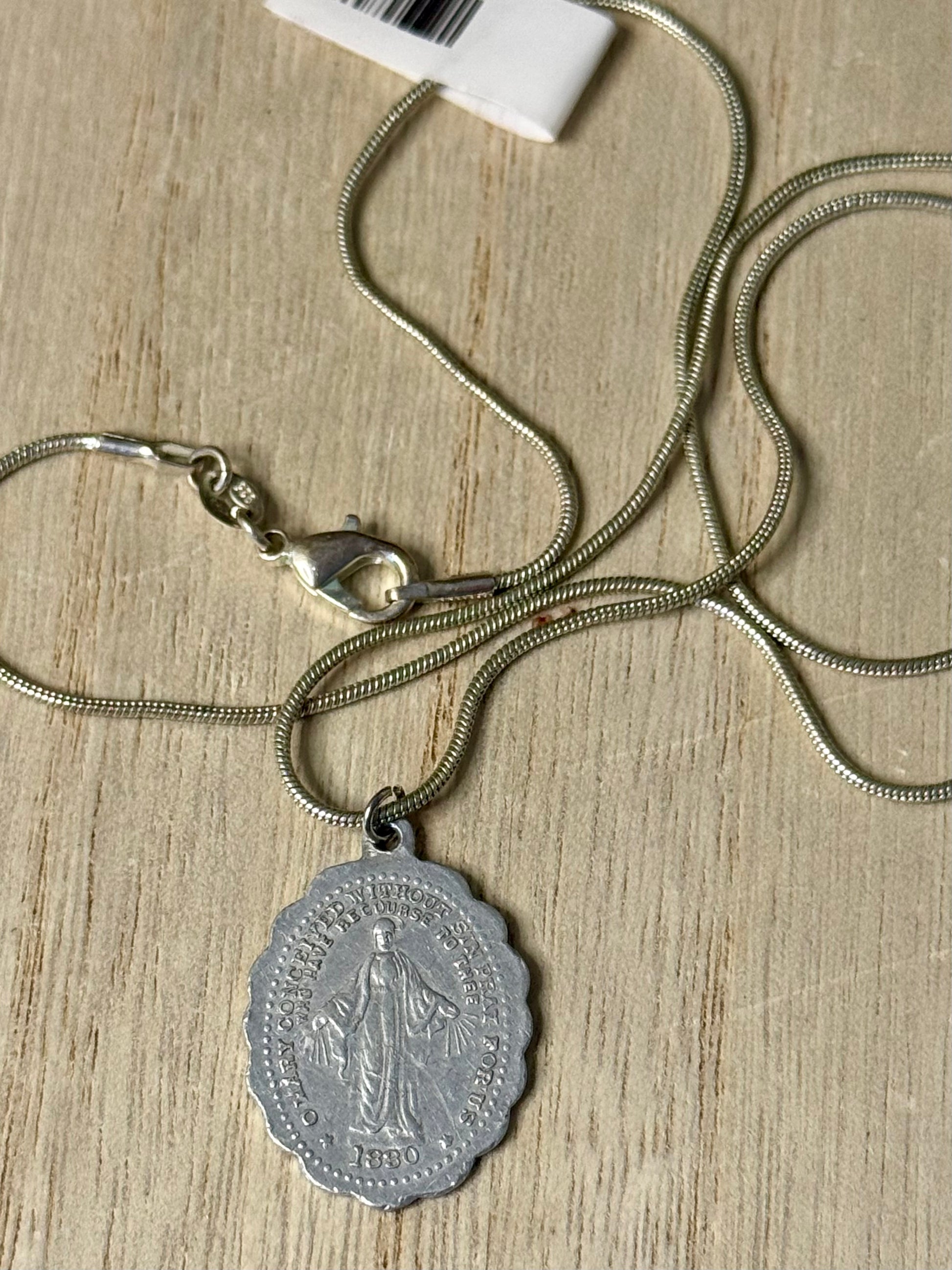 Silver necklace with a pendant on a wooden surface